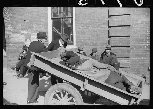 Untitled photo, possibly related to: Very often farmers must travel long distances at night or wait several days for tobacco to be sold. They can be found sleeping on the covered piles of tobacco in warehouses or in their trucks or the floors of camp rooms. Durham, North Carolina