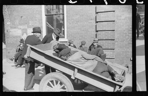 Untitled photo, possibly related to: Very often farmers must travel long distances at night or wait several days for tobacco to be sold. They can be found sleeping on the covered piles of tobacco in warehouses or in their trucks or the floors of camp rooms. Durham, North Carolina