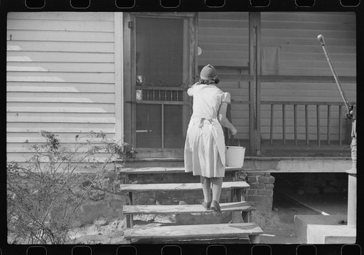 One of the Wilkins clan going into house with water. Tally Ho, near Stem, Granville County, North Carolina
