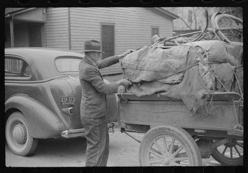 Untitled photo, possibly related to: Mr. Wilkins with trailer full of tobacco which he has brought to be auctioned at warehouse. On top of load is his son's bicycle which he brought to town to be repaired. Durham, North Carolina