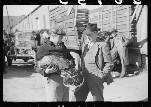 Farmer talking with with another farmer who has just purchased a turkey. Outside tobacco warehouse where auction sales are being held. Durham, North Carolina