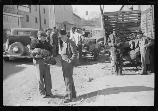 Untitled photo, possibly related to: Farmer talking with with another farmer who has just purchased a turkey. Outside tobacco warehouse where auction sales are being held. Durham, North Carolina