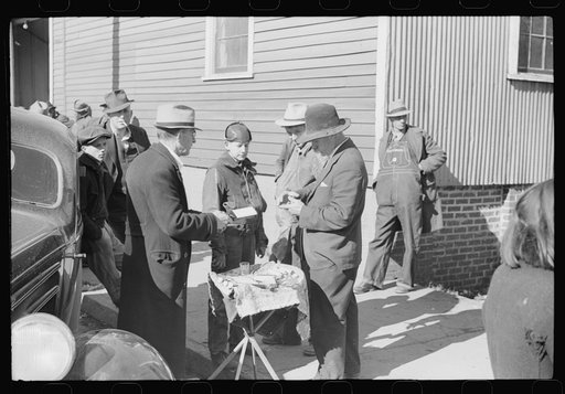Untitled photo, possibly related to: Salesman displaying patent medicine to farmers who have brought tobacco to warehouse and are waiting outside for the sales to begin. Mebane, North Carolina