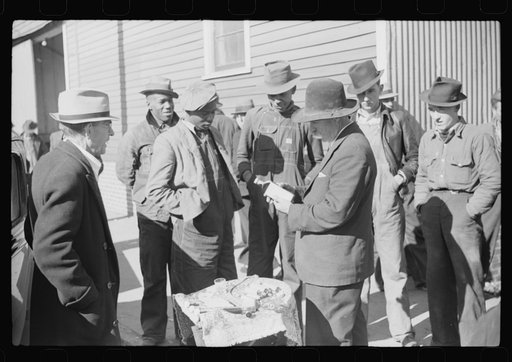 Salesman displaying patent medicine to farmers who have brought tobacco to warehouse and are waiting outside for the sales to begin. Mebane, North Carolina