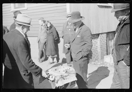 Untitled photo, possibly related to: Salesman displaying patent medicine to farmers who have brought tobacco to warehouse and are waiting outside for the sales to begin. Mebane, North Carolina