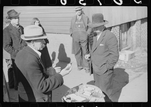 Salesman displaying patent medicine to farmers who have brought tobacco to warehouse and are waiting outside for the sales to begin. Mebane, North Carolina