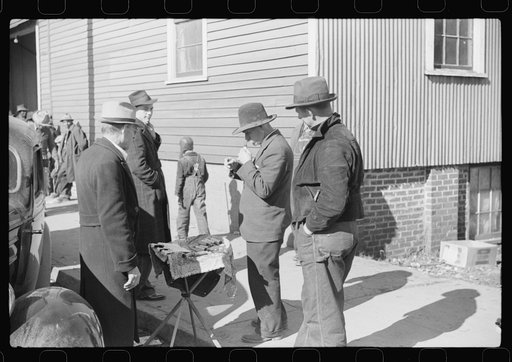 Salesman displaying patent medicine to farmers who have brought tobacco to warehouse and are waiting outside for the sales to begin. Mebane, North Carolina