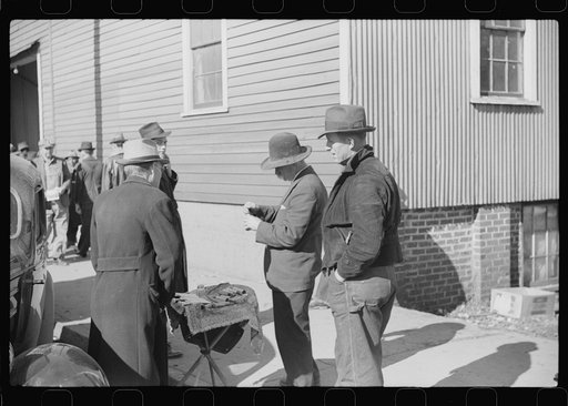 Untitled photo, possibly related to: Salesman displaying patent medicine to farmers who have brought tobacco to warehouse and are waiting outside for the sales to begin. Mebane, North Carolina
