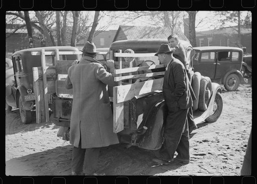 Untitled photo, possibly related to: Farmer selling pig to other farmers outside warehouse. Many farmers bring livestock and supplies to sell to other farmers when they come to town with their tobacco for auction. Mebane, North Carolina