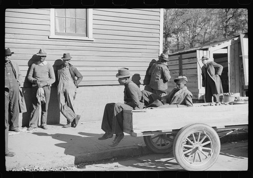 Untitled photo, possibly related to: Farmers waiting around outside warehouse for tobacco auction sale to begin. Tobacco was brought in trailer to warehouse. Mebane, North Carolina