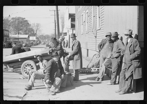 Farmers waiting around outside warehouse for tobacco auction sale to begin. Tobacco was brought in trailer to warehouse. Mebane, North Carolina
