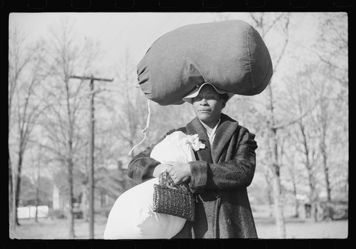 Untitled photo, possibly related to: Negro woman carrying laundry home along highway between Durham and Mebane, North Carolina