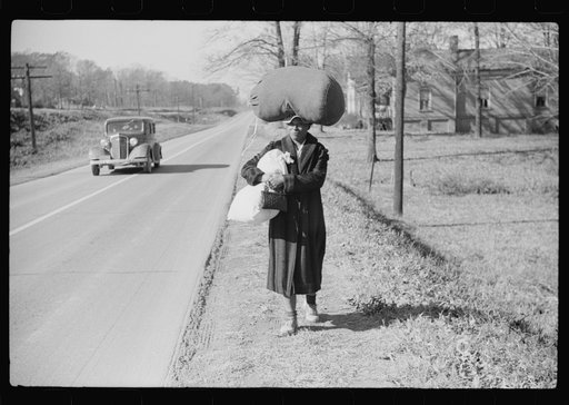 Negro woman carrying laundry home along highway between Durham and Mebane, North Carolina