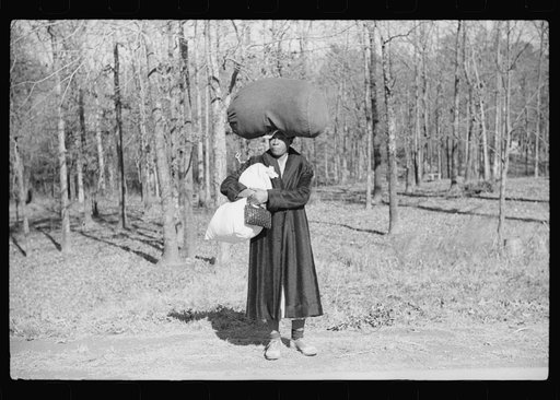 Untitled photo, possibly related to: Negro woman carrying laundry home along highway between Durham and Mebane, North Carolina