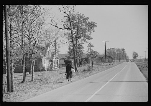 Untitled photo, possibly related to: Negro woman carrying laundry home along highway between Durham and Mebane, North Carolina