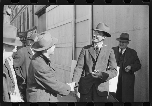 Tobacco auctioneer carrying sign "I bet on Carolina" to pay off a wager. He had to push the warehouseman in a wheelbarrow because North Carolina lost to Duke from the warehouse to the courthouse through the streets of Durham, North Carolina