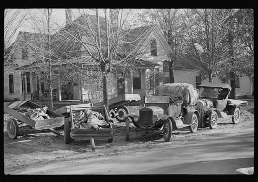 Trailers and cars belonging to farmers. They bring their tobacco for auction in all kinds of conveyances. Outside warehouse. Mebane, North Carolina