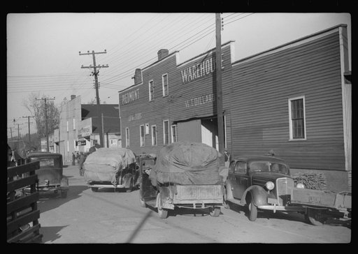 Untitled photo, possibly related to: Trailers and cars belonging to farmers. They bring their tobacco for auction in all kinds of conveyances. Outside warehouse. Mebane, North Carolina