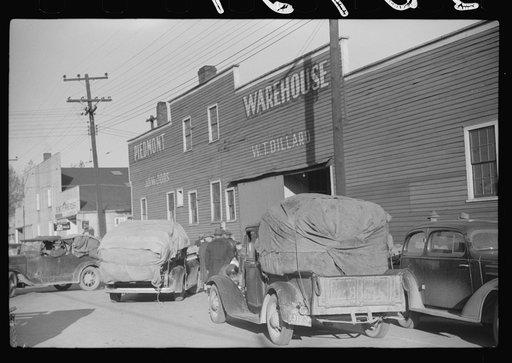 Untitled photo, possibly related to: Trailers and cars belonging to farmers. They bring their tobacco for auction in all kinds of conveyances. Outside warehouse. Mebane, North Carolina