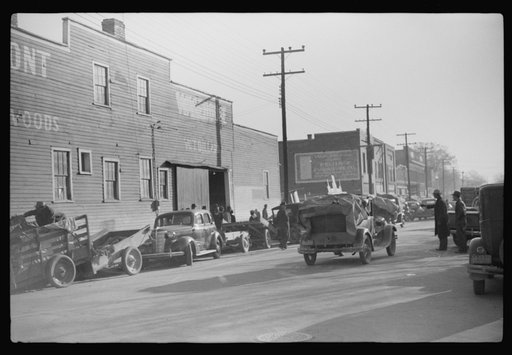 Untitled photo, possibly related to: Trailers and cars belonging to farmers. They bring their tobacco for auction in all kinds of conveyances. Outside warehouse. Mebane, North Carolina