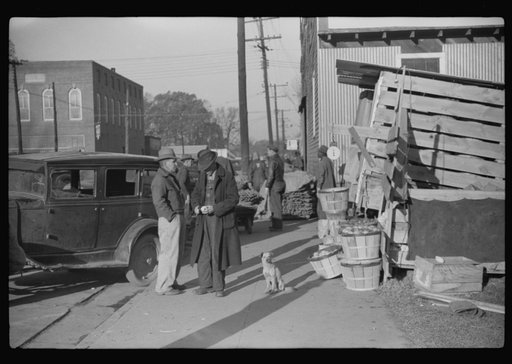 Untitled photo, possibly related to: Farmers and warehousemen unloading tobacco on sidewalk, before auction sale. The warehouse was too overloaded to permit more tobacco being brought in. Mebane, North Carolina