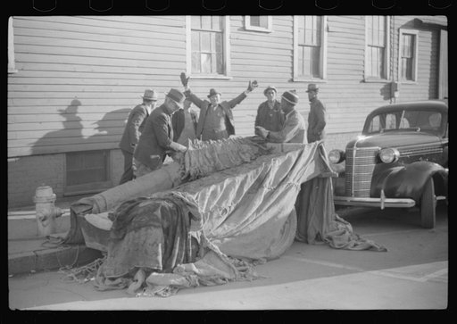 Untitled photo, possibly related to: Farmers and warehousemen unloading tobacco on sidewalk, before auction sale. The warehouse was too overloaded to permit more tobacco being brought in. Mebane, North Carolina