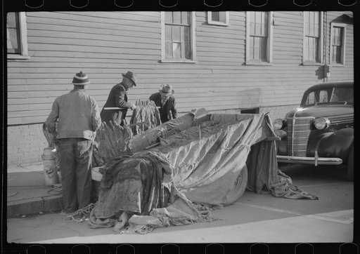 Untitled photo, possibly related to: Farmers and warehousemen unloading tobacco on sidewalk, before auction sale. The warehouse was too overloaded to permit more tobacco being brought in. Mebane, North Carolina