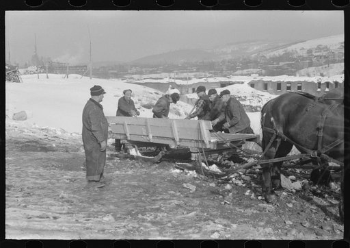 Workmen dumping the ice and snow from streets of Berlin, New Hampshire into river