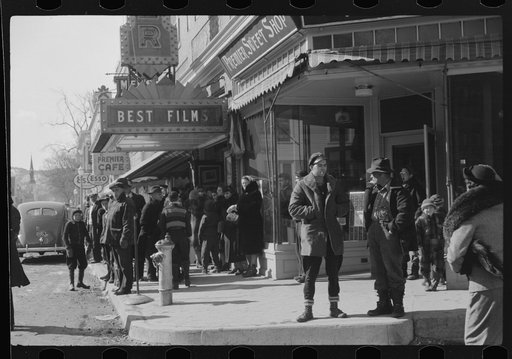 Untitled photo, possibly related to: Children and farmers waiting to go into movie on Saturday afternoon. Littleton, New Hampshire