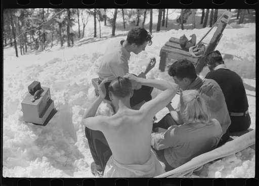 Skiers relaxing in the sun during noon hour outside of forest ranger's hut near the top of Mount Mansfield, Smuggler's Notch, near Stowe, Vermont