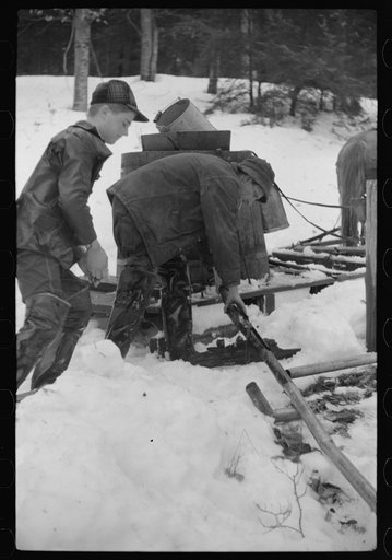 Untitled photo, possibly related to: Men of Walter Gaylord place connecting pipe line from the vat through which will run the sap from sugar maple trees. The line leadds to the sugar house where sap is boiled down into maple syrup. Mad River Valley, Waitsfield, Vermont. Gaylord averages about 150 ga