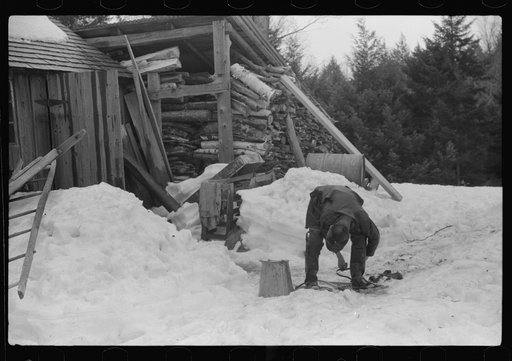 Untitled photo, possibly related to: Son of Walter Gaylord putting on snowshoes before going to gather sap from sugar maple trees. The snow was so deep that snowshoes were necessary to get around on. Mad River Valley, Waitsfield, Vermont. He averages about 150 gallons of syrup annually, this year ta