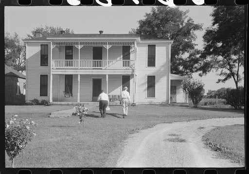 Priest going into rectory on church grounds during St. Thomas church picnic. Near Bardstown, Kentucky