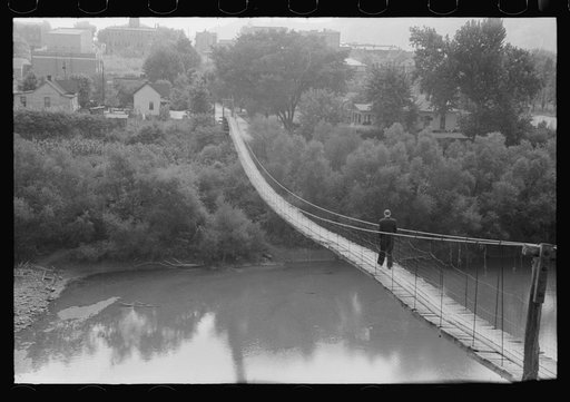 Untitled photo, possibly related to: Mountaineers crossing the Kentucky River over swinging bridge, carrying their supplies home from Jackson. Breathitt County, Kentucky