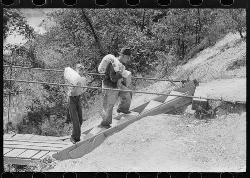 Mountaineers crossing the Kentucky River over swinging bridge, carrying their supplies home from Jackson, Breathitt County, Kentucky