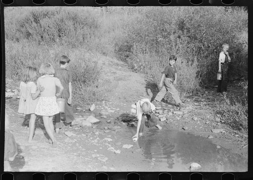 Untitled photo, possibly related to: Children going home from school up Frozen Creek carrying their lunch pails. School is held in the summer and stops in January because the creek beds, roads and inadequate clothing make it impossible for them to come in severe weather. Breathitt County, Kentucky