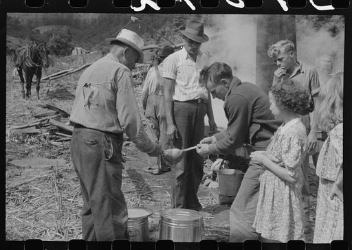 Untitled photo, possibly related to: Pouring off and straining finished sorghum syrup after it had been boiled down at a "syruping off" on the highway between Jackson and Campton, Kentucky