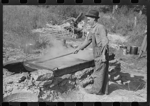 Untitled photo, possibly related to: Homebuilt boiler pit made of mud and rocks where the sap from the sorghum cane is boiled down to the syrup.The man who does the cooking goes from one farmhouse to another and takes a share of the syrup for his work at the different mountaineers' homes in Breathit