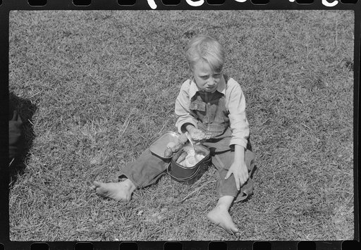 Child eating lunch during the noon hour at school in Breathitt County, Kentucky. In his lunch pail were cold potatoes, corn bread and mush