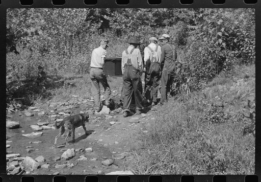 Mountain people carrying a homemade coffin up creek bed to the family plot on the hillside where it will be buried. This section is too isolated to hold any formal funeral services immediately. Up South Fork of the Kentucky River near Jackson, Kentucky