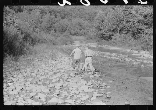 Going home from school. In Breathitt County, Kentucky. The school year begins in July and ends in January as most of the children have no shoes and insufficient clothing to walk the long distances over bad roads and up creek beds