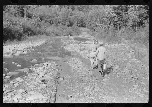 Untitled photo, possibly related to: Going home from school. In Breathitt County, Kentucky. The school year begins in July and ends in January as most of the children have no shoes and insufficient clothing to walk the long distances over bad roads and up creek beds