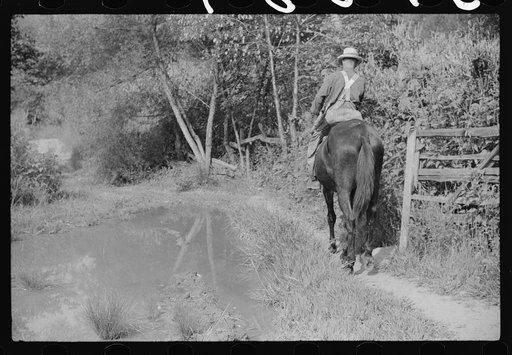 Untitled photo, possibly related to: Going home from school. In Breathitt County, Kentucky. The school year begins in July and ends in January as most of the children have no shoes and insufficient clothing to walk the long distances over bad roads and up creek beds