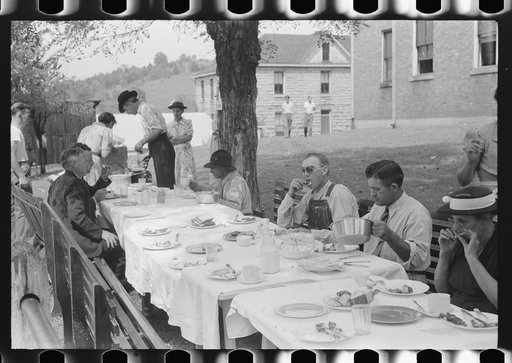 Mountaineers and farmers eating dinner served for benefit of the church in courthouse yard on court day. Campton, Wolfe County, Kentucky