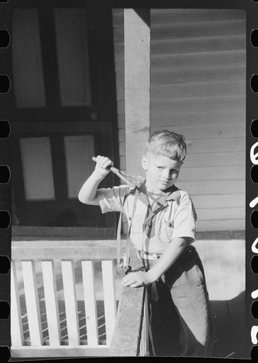 Untitled photo, possibly related to: Mountain child shooting slingshot from porch of his home. Near Buckhorn, Kentucky