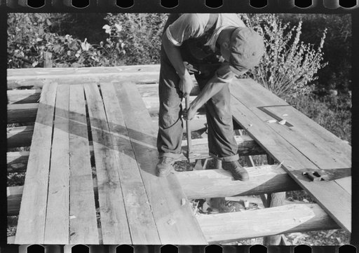 Mountaineer laying the new floor in his neighbor's home near Jackson, Breathitt County, Kentucky
