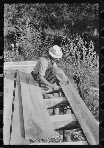 Mountaineer laying the new floor in his neighbor's home near Jackson, Breathitt County, Kentucky