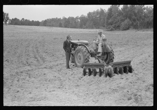 Connie B. Gay, FSA (Farm Security Administration) county supervisor talking to Emery Hooper about his tractor and disc plow purchased with a FSA cooperative community service loan. Near Prospect Hill, Caswell County, North Carolina