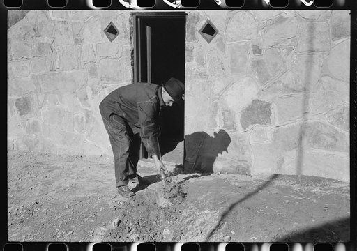 Untitled photo, possibly related to: Mr. S. Castle or Mr. William S. Allen working in front of new storage house he built on their farm with FSA (Farm Security Administration) help. Southern Appalachian project, near Barbourville, Knox County, Kentucky. Mr. William S. Allen cleaning up yard in front