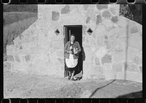 Untitled photo, possibly related to: Mrs. S. Castle or Mrs. William S. Allen with canned goods in front of new storage house her husband built on their farm with FSA (Farm Security Administration) help. Southern Appalachian project, near Barbourville, Knox County, Kentucky